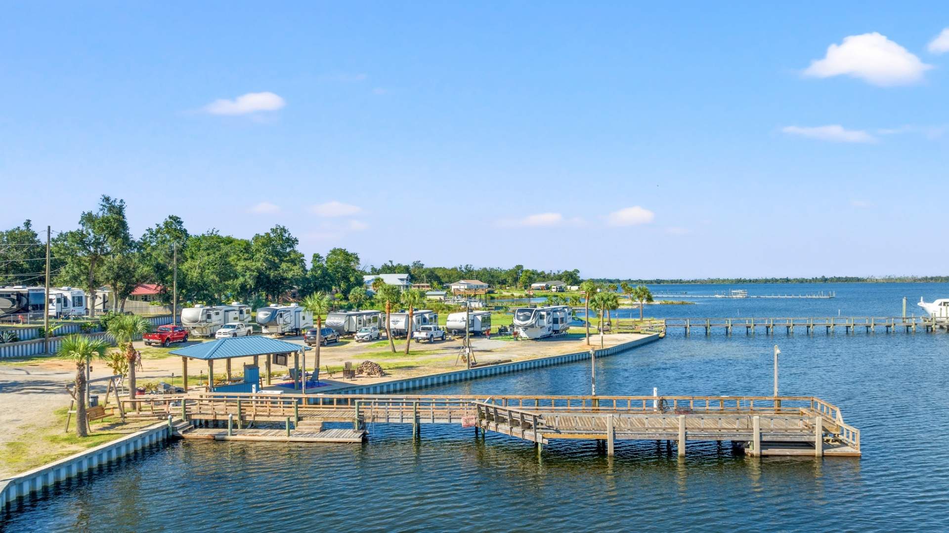 travel nurses get a view from the bay of pier, pavillion, palm trees and rv campers at Nautical Point RV Park.